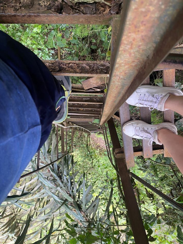 ruta por indonesia vista hacia abajo de una escalera de hierra y dos personas bajando